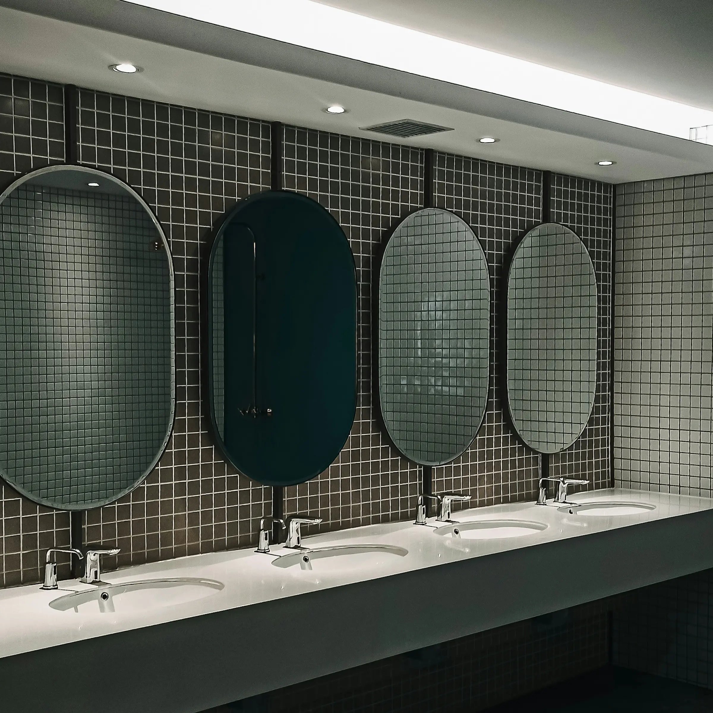 Rangée de lavabos dans des sanitaires collectifs contemporains